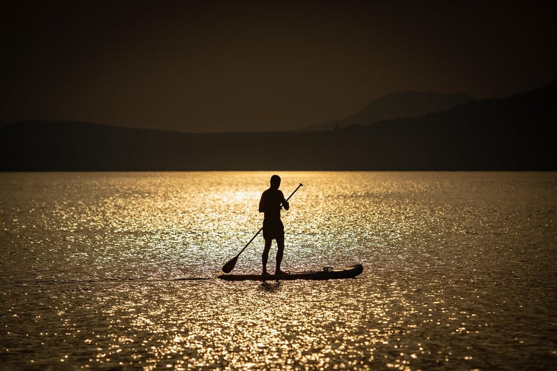 Person paddleboarding on calm waters